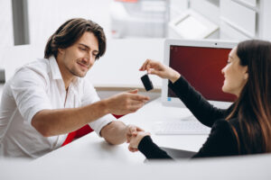 Man talking with female sales person in a car show room vehicle loan